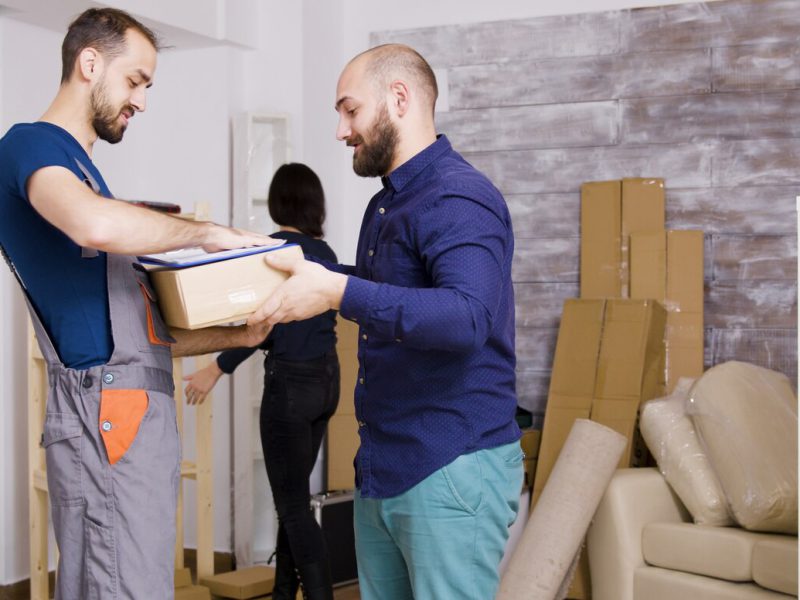 man-from-delivery-service-arriving-with-boxes-documents-be-signed-beautiful-young-couple-moving_482257-22217